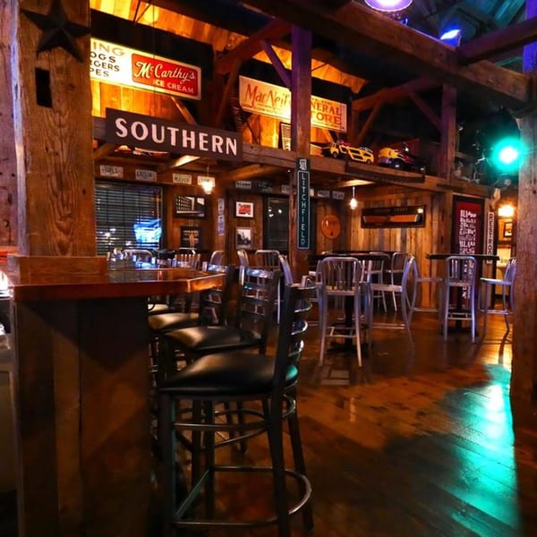 Rustic interior of KC's Rib Shack, featuring a bar area, dining tables, and vintage signs.